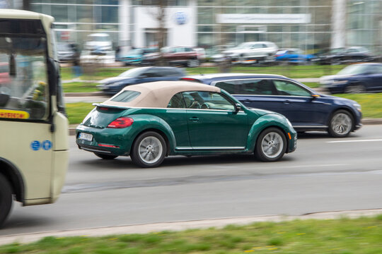 Ukraine, Kyiv - 20 April 2021: Green Volkswagen Beetle car moving on the street. Editorial