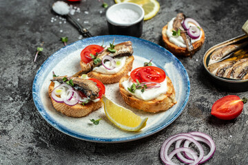 Appetizing sandwiches with sprats on white plate. Food recipe background. Close up