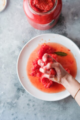 Hand holding and squeezing tomato