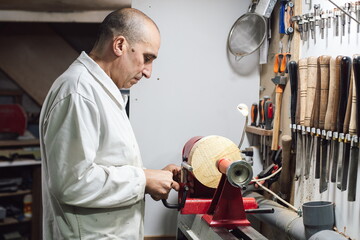 Joinery worker shaping a piece of wood on the lathe
