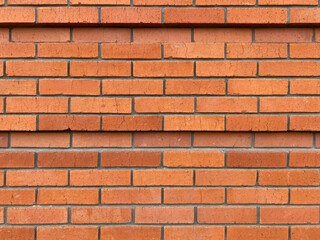 Red brick wall in rows, tiers. With small cracks. Masonry, ledge, 2 lines of recess, deepening