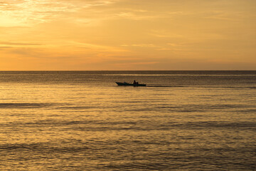 Fototapeta premium Fishing boat in the Gulf of Tomini at sunset, seen from the coastal and port city of Ampana in the north of Sulawesi in Indonesia