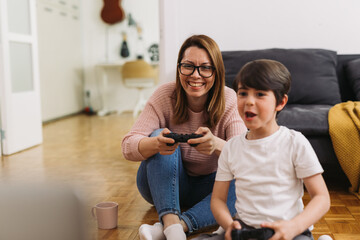 mother and her son playing video games at home