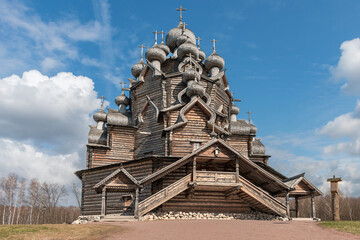 Fototapeta na wymiar Old historic wooden church in the suburbs of the Russian city of St. Petersburg against the background of a blue cloudy sky