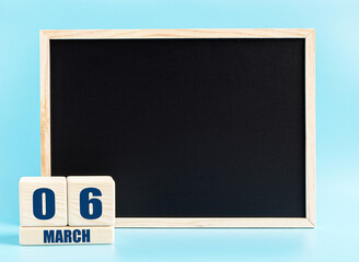 March 6. Day 6 of month, Cube calendar with date, empty frame on light blue background. Place for your text. Spring month, day of the year concept