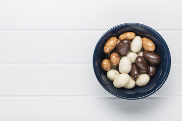 Sweet chocolate almonds. Chocolate eggs in bowl.