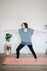 Fototapeta premium mature caucasian senior woman practicing yoga pose at home. Healthy lifestyle