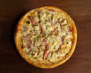 Top view of whole pizza of pork loin with cream cheese and pineapple or lombo ao creme com abacaxi.