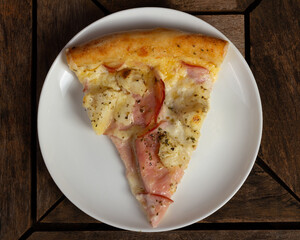 Top view of a slice of pizza in white plate of pork loin with cream cheese and pineapple or lombo ao creme com abacaxi