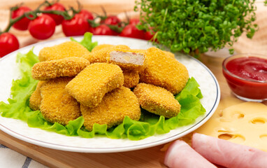 Chicken nuggets with ham and cheese on a plate. Cordon bleu. Appetizer.