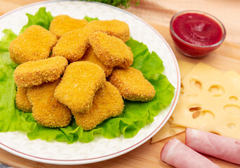 Chicken nuggets with ham and cheese on a plate. Cordon bleu. Appetizer.