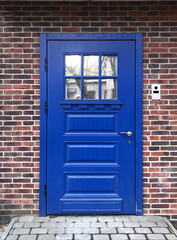 Fototapeta premium Beautiful blue door in a brick wall
