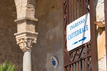 Fototapeta premium Cefalù, Italy - May 8, 2019: Signage Ingresso Cattedrale, Italian for Cathedral entrance