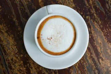 Coffee in a white cup with milk foam on top