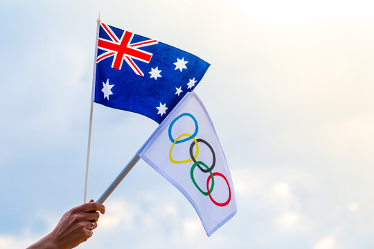 Fan waving the national flag of .Australia and the Olympic flag with symbol olympics rings.