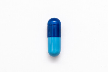 Close-up one blue powder soft capsule pill isolated on white background. medicine supplement vitamin