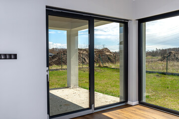 Large terrace windows overlooking the garden, the view from inside the living room on the floor are vinyl panels.