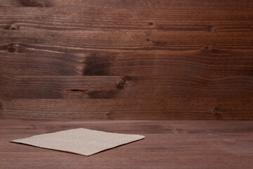 Isolated brown paper napkin on wooden background.