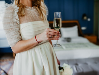 bride drinking wine on her wedding day white dress	
