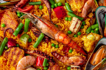 Paella. Spanish dish of rice and seafood, vegetables and chicken. Shrimp, octopus, crab and mussels. Banquet festive dishes. Gourmet restaurant menu. White background. Pattern