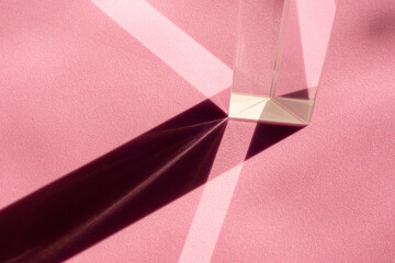 Straight geometric shapes of light and shadow in abstraction on pink