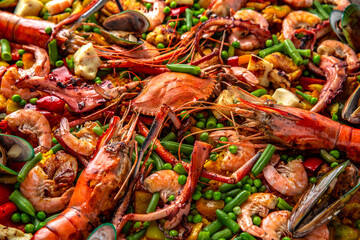 Paella. Spanish dish of rice and seafood, vegetables and chicken. Shrimp, octopus, crab and mussels. Banquet festive dishes. Gourmet restaurant menu. White background. Pattern