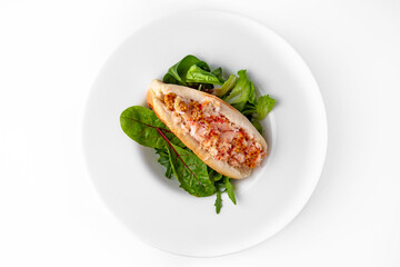 Hot dog with crab meat, mustard and herbs. Banquet festive dishes. Gourmet restaurant menu. White background.