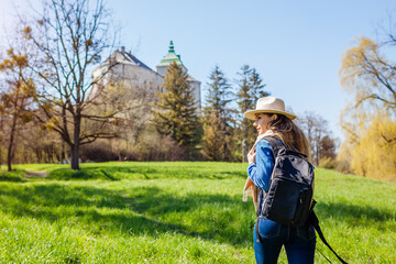 Fototapeta premium Tourist walking in Olesko Castle garden. Ancient architecture landmarks in Western Ukraine. Traveling