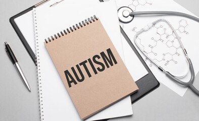 Inscription autism. Top view of the table with stethoscope,pen and medical documents. Health care concept.