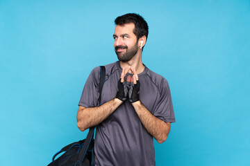 Young sport man with beard over isolated blue background scheming something