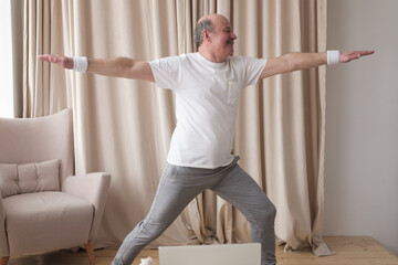 Elderly man practicing yoga or fitness. Positive mood on sports activities