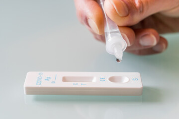 Drop of a test material in a rapid test cassettee  for covid-19 antigen test.