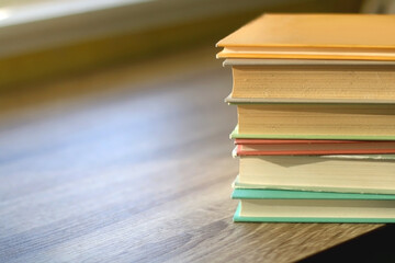 Stack of colorful books on a table. Selective focus.