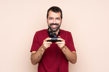 Man playing with a video game controller over isolated wall