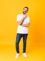 Fototapeta na wymiar Full-length shot of man with beard over isolated yellow background smiling