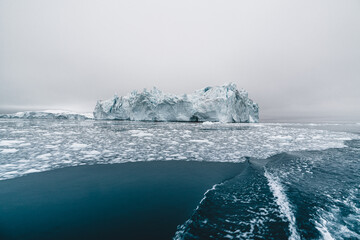 Arctic nature landscape with icebergs in Greenland icefjord with midnight sun sunset sunrise in the...