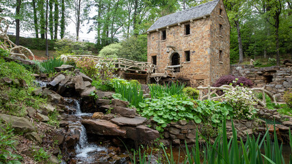 Fototapeta na wymiar old stone Mill in spring water flowing