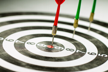 The red dart hits right on target. Winner.