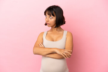 Fototapeta na wymiar Young pregnant woman over isolated pink background keeping the arms crossed