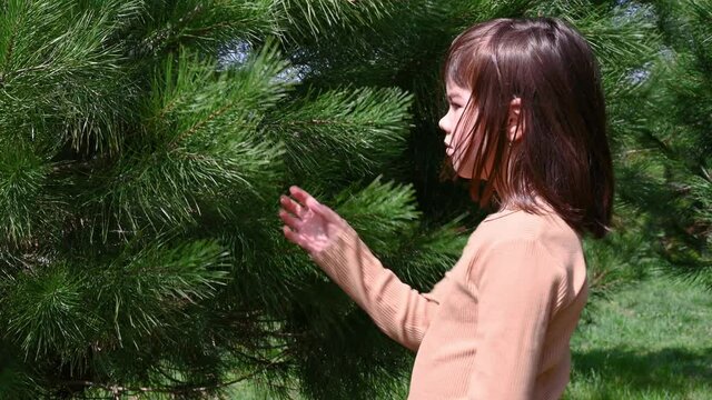 girl schoolgirl 8 years old inhales fresh air during the day near green trees in spring. High quality footage
