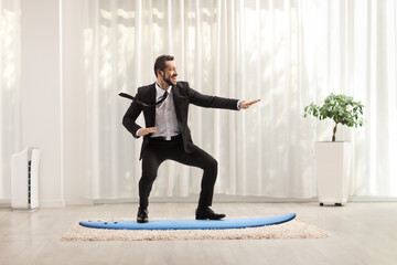 Businessman practicing surfboard riding at home
