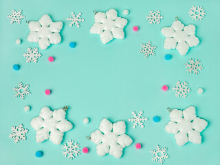 Frame of snowflakes on light blue background, pastel colors Christmas holiday composition top view, copy space, flat lay