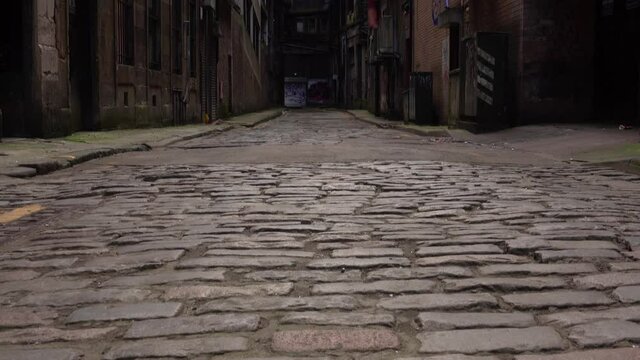 Tilt Reveal Shot Of A Grungy Empty Urban Back Alley With Cobblestones