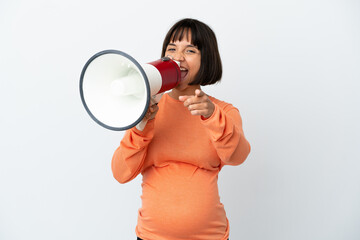 Young mixed race pregnant woman isolated on white background shouting through a megaphone to announce something while pointing to the front