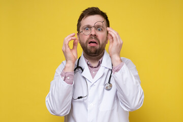 Terrified doctor in stress, he nervously adjusts glasses and looks in disbelief with a stupid...
