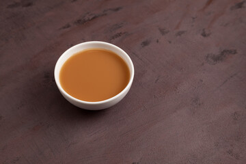 Traditional Tibetan butter tea or churned tea in white bowl. Selective focus. Asian drink known as 