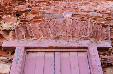 Old red standstone entrance of a cottage with wooden door
