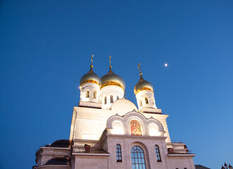 Orthodox Church against the background of the blue evening sky and moon.