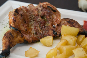 Roasted little chicken pollo picanton with fries on plate Spain