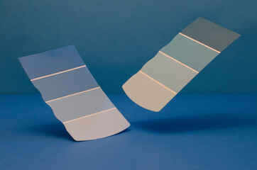 3d paint color samples in blue and white falling in a blue space.	